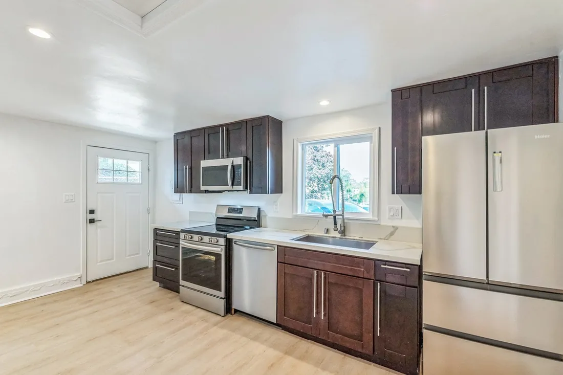 White kitchen remodel with stainless appliances by Merribuild