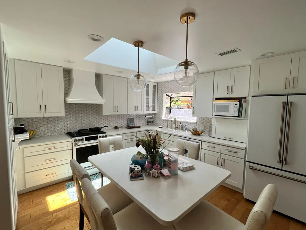 White kitchen remodel with skylight and island by RCS Pro Build