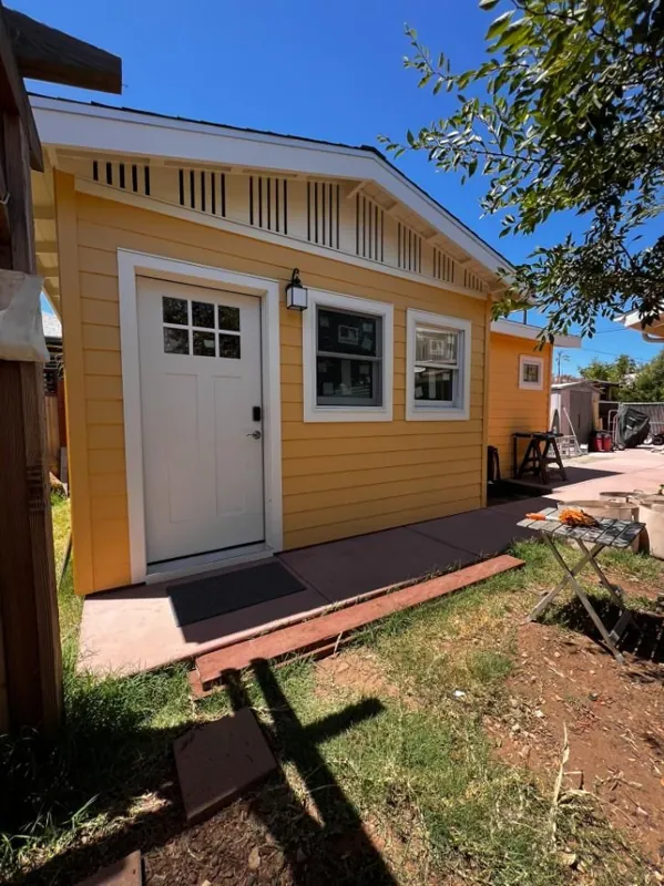 Yellow ADU cottage with white trim by RCS Pro Build