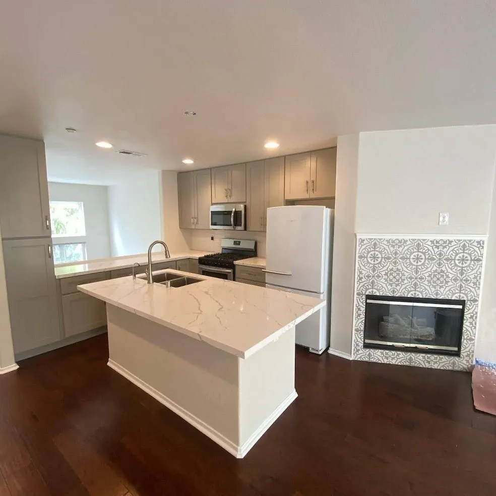 Kitchen remodel with island and tiled fireplace by RCS Pro Build