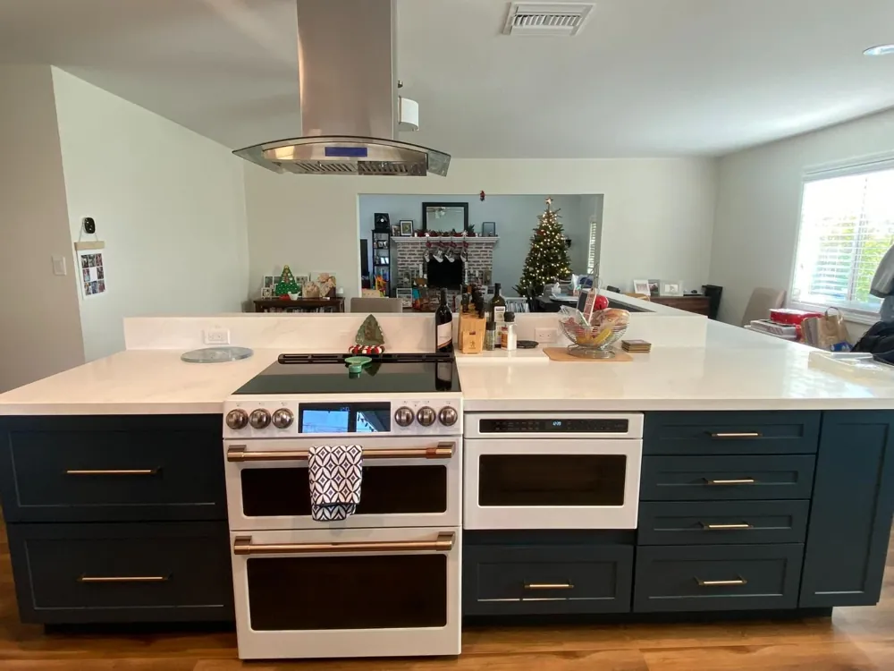 Navy kitchen with white range and quartz counters by RCS Pro Build