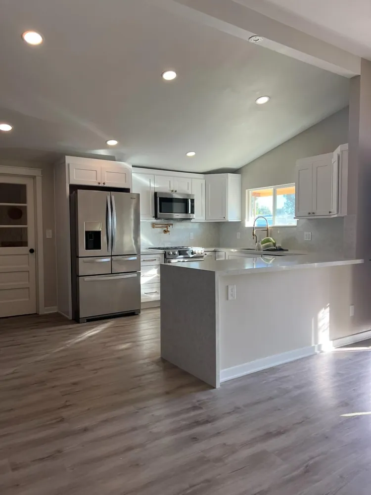 Bright white kitchen with stainless appliances by RCS Pro Build